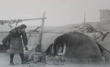 Laguna Indian woman at her horno (oven) baking bread