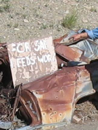 Frank Young with a For Sale Needs Work sign near Cerrillos, New Mexico