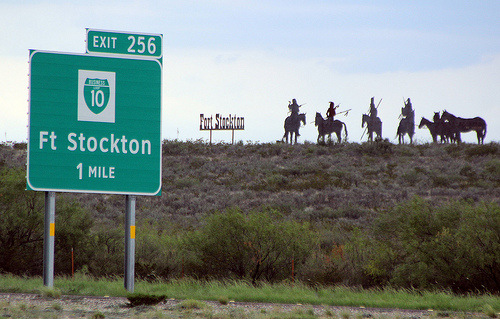 Exit 256 sign for Ft Stockton on I-10 with silouettes on hill