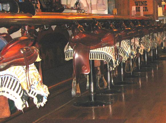 Saddles line bar in the Million Dollar Cowboy Bar in Jackson, Wyoming across from Town Square Park
